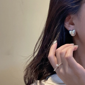 Chic S925 sterling silver heart-shaped hoop earrings with smooth mirror finish on model