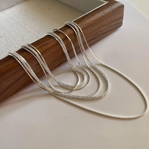 Elegant multi-layered S925 sterling silver square snake chains on wooden display
