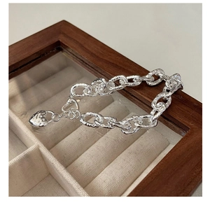 Dettaglio del bracciale in argento S925 con maglie testurizzate e ciondolo a cuore