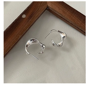Close-up of S925 sterling silver hoop earrings with unique wavy texture and polished finish
