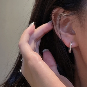 Minimalist S925 sterling silver hoop earrings with hammered texture shown on model