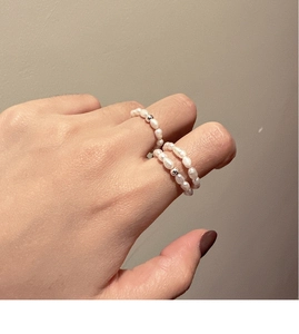 Detail of two freshwater pearl elastic rings with silver beads on a model hand