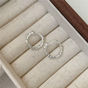 S925 sterling silver hoop earrings with irregular hammered texture in a jewelry box