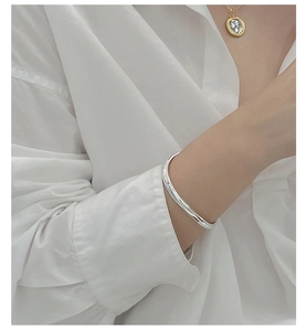 Polished S925 sterling silver wavy bangle on wrist with a minimalist mirror finish