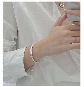 Minimalist S925 sterling silver curved bangle shown on wrist with polished mirror finish