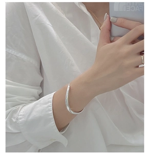 Polished S925 sterling silver minimalist wavy cuff bracelet shown on model's wrist