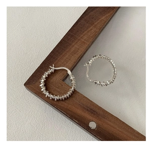 Close-up of S925 sterling silver hoop earrings with textured finish and metal hallmark