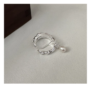 Macro shot of S925 sterling silver textured ring with dangling water drop pearl