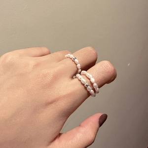 Set of two elastic freshwater pearl rings with S925 silver bead on woman's finger