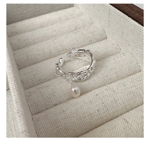 Detailed macro view of S925 silver lava texture ring with a hanging teardrop pearl charm