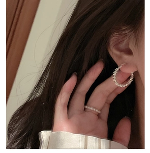 Close-up of S925 sterling silver hammered hoop earring and matching beaded ring on model