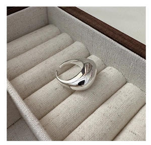 Macro shot of minimalist teardrop silver ring displayed in a jewelry storage box