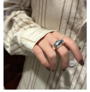 Detailed view of minimalist wide silver ring paired with a dainty freshwater pearl ring