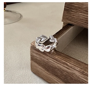 Detailed view of connected heart-shaped links on polished silver adjustable ring