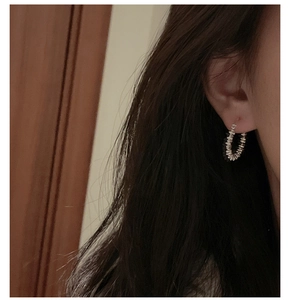Detailed view of silver beaded hoop earrings worn on ear with textured vintage design