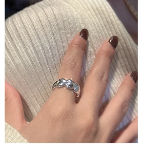 Macro detail of three interconnected silver heart elements on a polished S925 silver ring