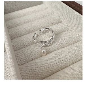 Macro detail of S925 silver irregular lava ring with pearl and chain on velvet box