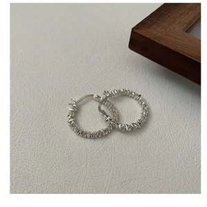 Close-up of S925 sterling silver hoop earrings with textured twisted rope design