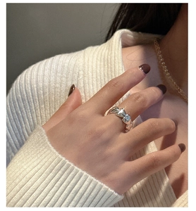 Close-up of S925 sterling silver ring with flowing heart ribbon design on finger