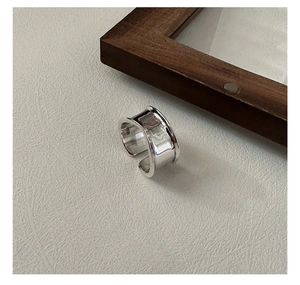 Primer plano de un anillo ancho de plata esterlina S925 con superficie cóncava irregular
