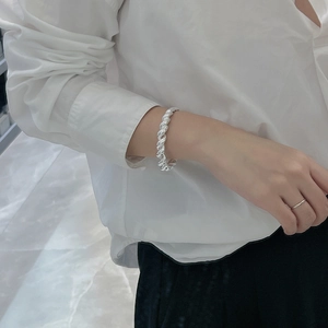 Bracelet jonc torsadé en argent sterling S925 porté au poignet pour un style minimaliste