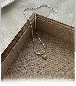 Vue macro de la chaîne à billes en argent S925 bicolore avec pendentif LOVE doré
