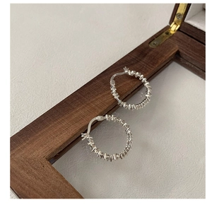 Close-up of S925 sterling silver hoop earrings with textured wire wrapped design
