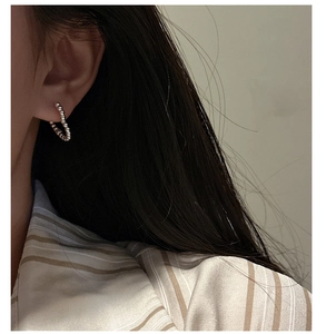 Detail of S925 sterling silver hoop earring with beaded texture worn by a model
