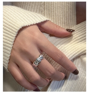 Close-up of a S925 sterling silver ring with connected heart shapes on a finger