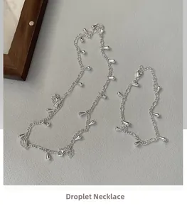 Detail of silver S925 teardrop necklace and bracelet set with polished droplet pendants