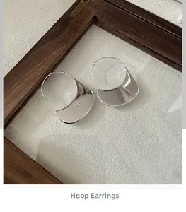 Close-up of minimalist S925 sterling silver crescent earrings with polished finish