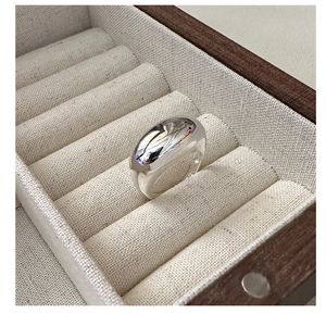 Detail showing the chunky S925 sterling silver ring with a polished mirror finish surface