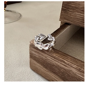 Detailed view of interconnected heart patterns on a polished S925 silver open ring