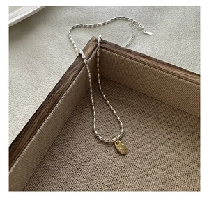 Gros plan détaillé d'un collier en argent S925 avec pendentif ovale doré LOVE