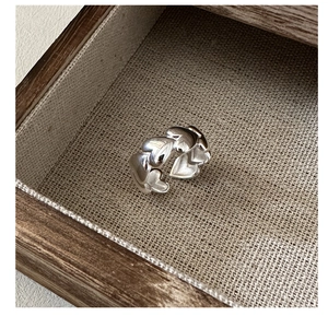 Detailed macro shot of 925 sterling silver heart-linked ring on a rustic wooden box