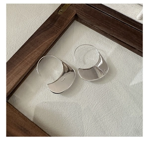 Macro detail of minimalist S925 sterling silver hoop earrings with polished finish