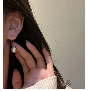 Close-up of elegant S925 sterling silver teardrop earrings on model for a modern look