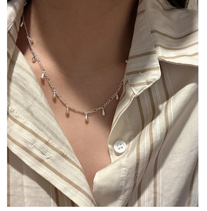 Close-up of S925 sterling silver necklace with water drop tassels on a model neckline