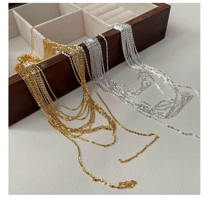 Detail of minimalist S925 sterling silver tassel necklace chains in gold and silver