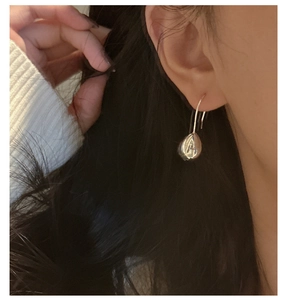 Detailed close-up of polished S925 silver teardrop earring on model showing elegant finish