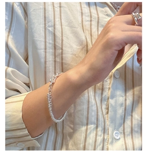 Close-up of S925 sterling silver abacus bead bracelet and layered ring on hand