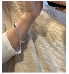 Close-up of S925 sterling silver bangle with water ripple texture worn by a model