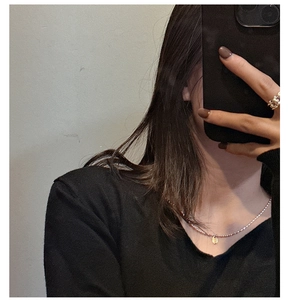 Détail d'un collier de perles argentées avec pendentif ovale doré sur un mannequin