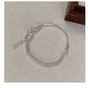 Detail of silver S925 beads and sleek metal bangle structure with adjustable chain