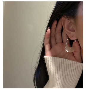 Close-up of S925 sterling silver minimalist U-shaped hook earrings on model