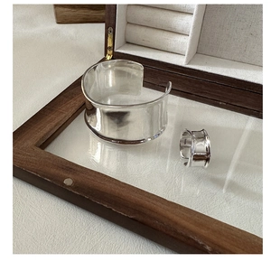 Detalle de conjunto de anillo y brazalete ancho en plata de ley S925 en joyero elegante
