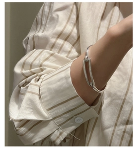 Detail view of a polished S925 sterling silver cuff with a unique geometric buckle closure