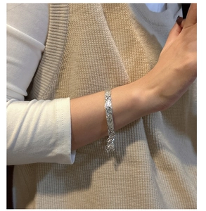 Detailed close-up of textured S925 sterling silver bangle with a hammered lava surface effect