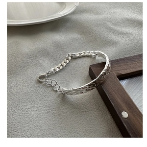 Macro shot of S925 silver bracelet featuring hammered texture and chunky Cuban link chain