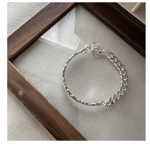 Detail of S925 silver bracelet featuring handcrafted texture and a classic cuban chain